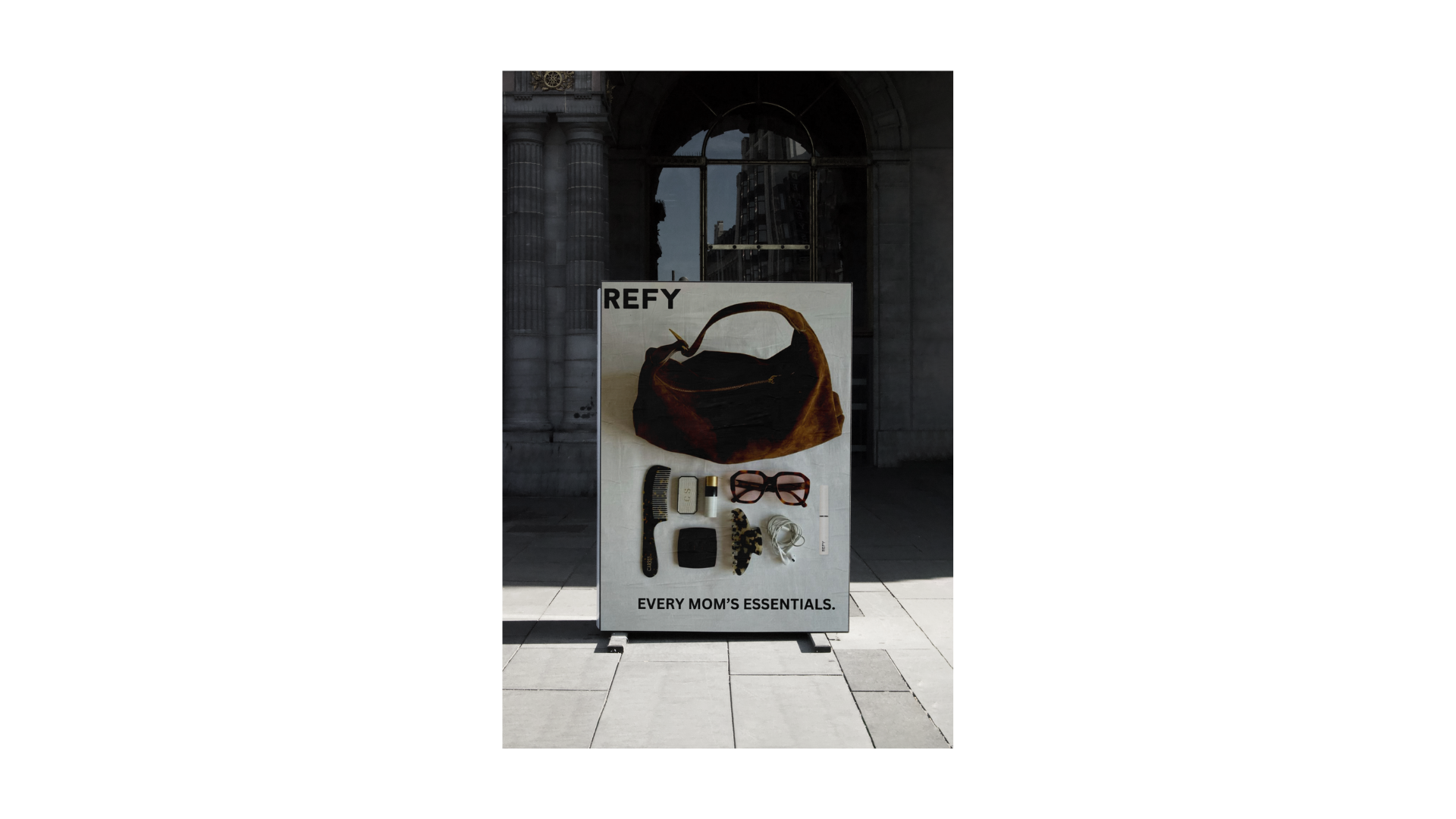 Bus-stop OOH — the Brow Sculpt staged inside a mom's actual essentials, with the line 'Every mom's essentials'